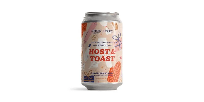 Host & Toast non-alcoholic Belgian-style white ale showcasing light, crisp character with citrus and spice notes against plain background